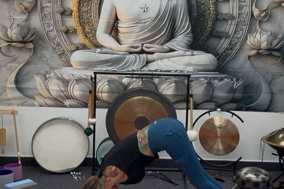 A yoga pose held in front of the studio's gongs