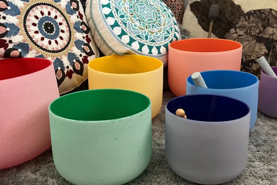 Colorful crystal singing bowls lined up for a sound bath