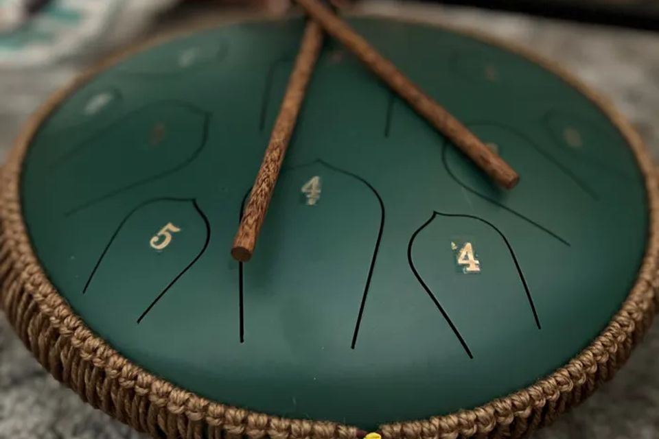 A steel tongue drum with mallets used in sound sessions